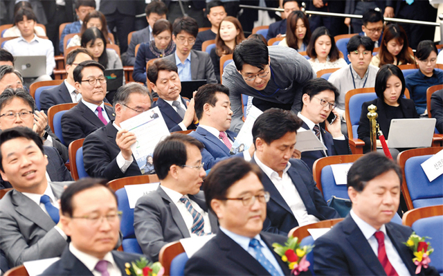 의원 총회에서 박 의원에게 청와대 방문 일정 변경 사실을 알리고 있다.