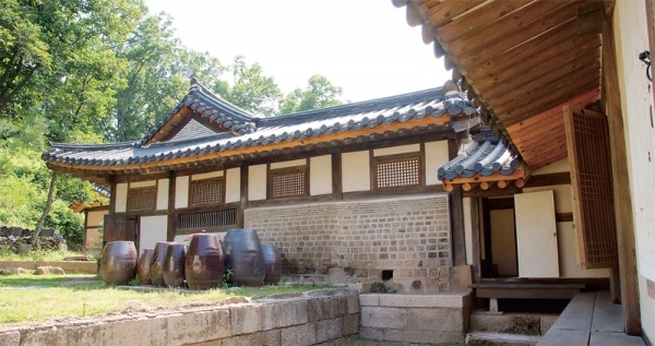 가로 봉창이 보이는 안채 부엌. 안채 쪽 담은 벽돌을 구워 단정하게 마감했다. 오른쪽 살짝 보이는 건물이 사랑채인데, 퇴가 달려있어 바로 안채로 건너갈 수 있다. 3단 석재를 받쳐 장독대를 놓고 그 뒤로 우물을 팠다.