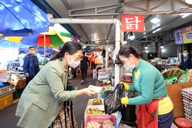 ▲ 은수미 성남시장이 전통시장에서 지역상품권으로 물건값을 치르고 있다