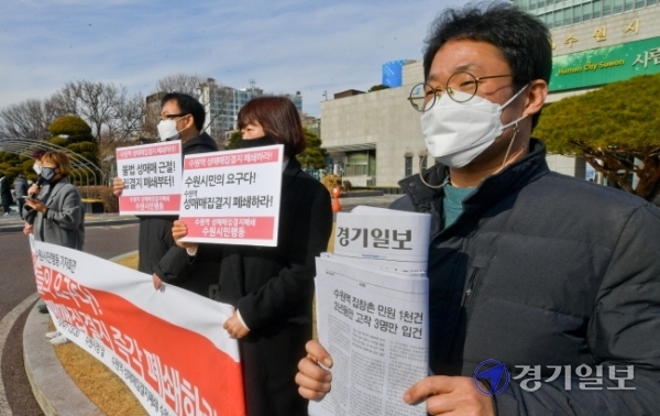 27일 수원시청 앞에서 수원역 성매매집결지 폐쇄 수원시민행동 관계자들이 지자체와 경찰을 규탄하는 기자회견를 하며 본보 27일자에 보도된 수원역 성매매집결지 관련 보도를 보이고 있다. 윤원규기자