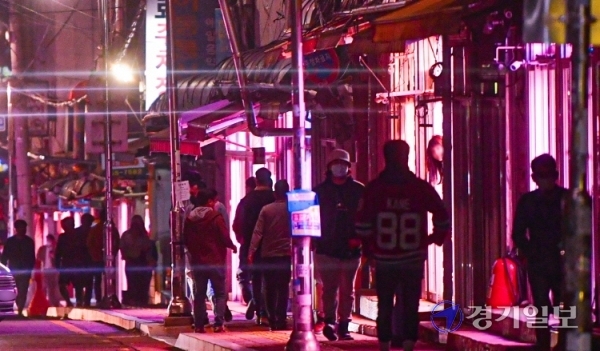 지난 8일 밤 수원역 성매매 집결지에서 남성들이 일부 영업중인 성매매업소 앞을 서성이고 있다. 조주현기자