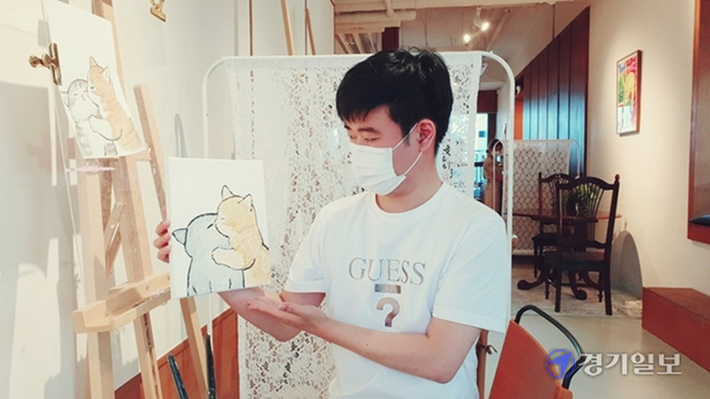 방문객 이윤직(34)씨가 완성된 자신의 작품(고양이 그림)을 들고 드로잉 체험 소감을 말하고 있다.