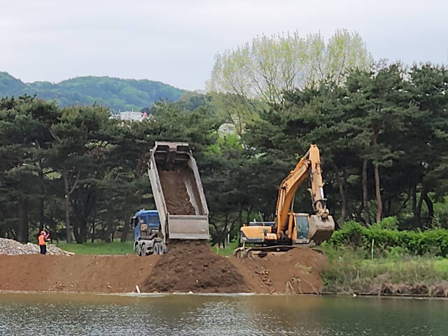 가평군 가평읍 달전리 자라섬 서도 인근에서 수변생태관광벨트 조성공사릉 위해 덤프트럭과 포크레인 등이 물막이작업을 하고 있다. 신상운기자