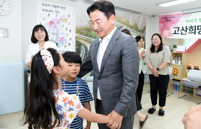 김동근 의정부시장이 고산희망타운 다함께돌봄센터에서 어린이의 손을 잡고 이야기하고 있다. 의정부시 제공