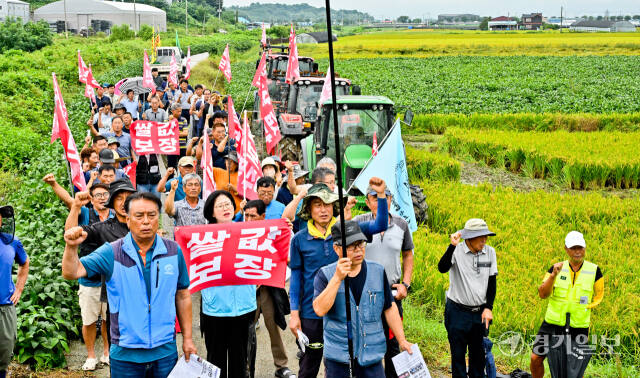 12일 오전 안성시 미양면 한 논에서 전국농민총연맹 경기도연맹 관계자와 지역농민들이 쌀값 보장 등을 요구하며 구호를 외치고 있다. 윤원규기자